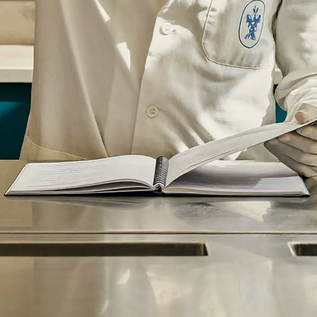 Cuaderno de registro clínico abierto sobre la mesa de exploración.